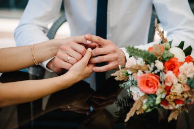 Gelin ve damat şık düğün buket yakınındaki elele