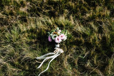 Yumuşak pastel çiçek ve pembe gül ve yeşil yeşil çim zemin üzerine gelin buketi