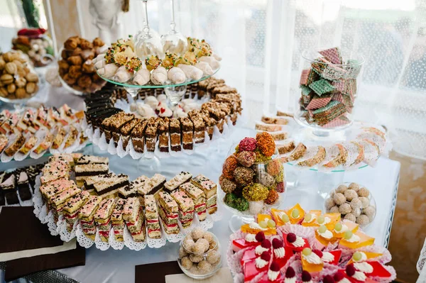 Sweet table with assorti of sweets on wedding holiday