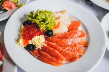 Kırmızı havyar görünümünü kapatın ve beyaz plaka üzerinde balık