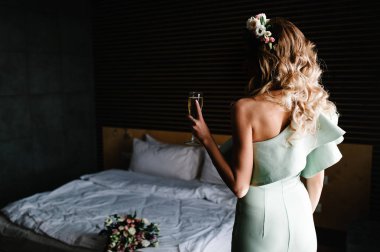 Şampanya tutan gelinin arkadan görünüş