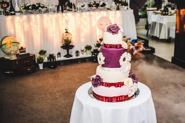 Table with wedding cake decorated with flowers