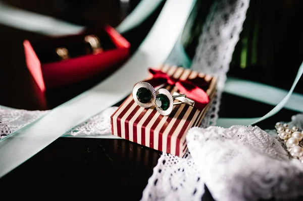 スタイリッシュな花嫁ウエディング リボンとガーター ボックスとカフリンクスのゴールドの結婚指輪 — ストック写真
