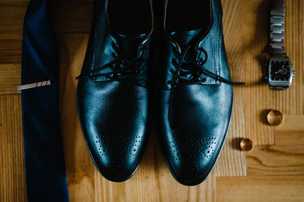 şık erkekler siyah ayakkabılar, kravat, izle, hafif kahverengi masanın üzerinde yatan iki alyans Lake