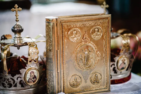 İncil'de altın ve simgeler, kilisede masada duran düğün kron ile dekore edilmiş