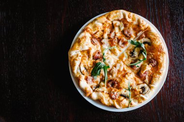 Roka kahverengi ahşap masa üzerinde İtalyan et pizza 