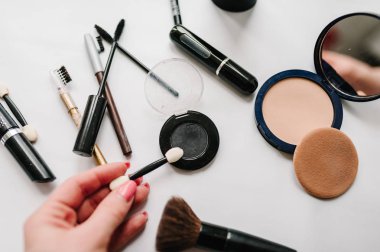 kadın el fırça göz farı için ışık beyaz arka plan üzerinde tutarak 