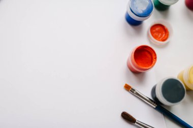 Sanatçının renkli kalemler, suluboya, boyalar, fırçalar, sketchbook, beyaz kağıt üzerinde beyaz tablo ile çalışma alanı