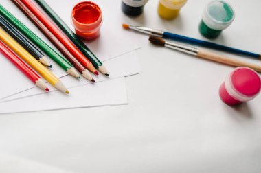 Sanatçının renkli kalemler, suluboya, boyalar, fırçalar, sketchbook, beyaz kağıt üzerinde beyaz tablo ile çalışma alanı