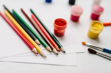 Sanatçının renkli kalemler, suluboya, boyalar, fırçalar, sketchbook, beyaz kağıt üzerinde beyaz tablo ile çalışma alanı