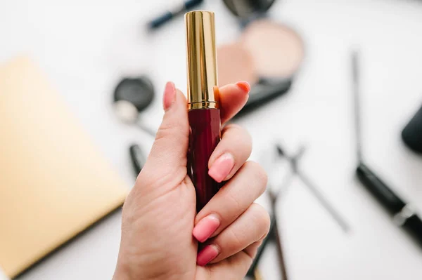 Tangan Wanita Memegang Lipstik Pada Latar Belakang Kabur Dari Kosmetik — Stok Foto