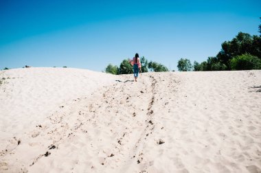 arkadan görünüşü şık seksi genç kız kumlu plajda, parti boho tarzı yürüyüş. Hen-partiler akşam kızlık 