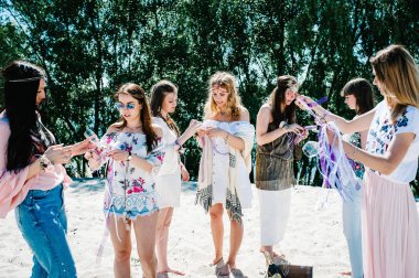 Güzel seksi gelin arkadaşlar kumsal, şampanya bardağı mahyalara çiçek boutonnieres ile. Parti boho tarzı. Hen-partiler akşam kızlık 