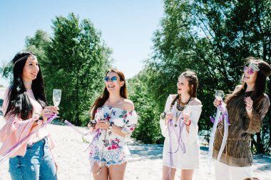 Güzel mutlu şık seksi genç kızla gözlük kumlu Plajı'nda şampanya içme ellerinde çiçek boutonnieres. Parti boho tarzı. Hen-partiler akşam kızlık 