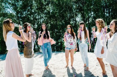 Güzel mutlu şık seksi genç kızla gözlük kumlu Plajı'nda şampanya içme ellerinde çiçek boutonnieres. Parti boho tarzı. Hen-partiler akşam kızlık 