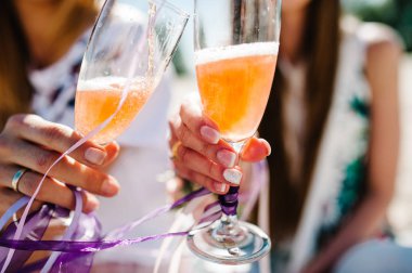 çiçek boutonnieres glasss şampanya ile kumlu plajda parti boho tarzı holding ile eller. Hen-partiler akşam kızlık. 