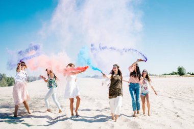 Plajda, bekarlığa veda partisi boho tarzı renkli sis bombası aydınlatan ile eğlenmek güzel mutlu şık seksi genç kız 