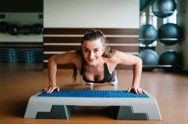 Sportif kadın şınav mı adım platform, aerobik jimnastik salonu kavram üzerinde