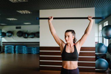 Spor Salonu, spor eğitim kavramı barda vücut ile egzersiz yaparak güçlü sportif kadın