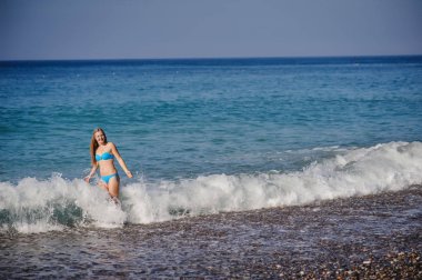 Genç kadın yüzme ve dalgalı denizde eğlenmek