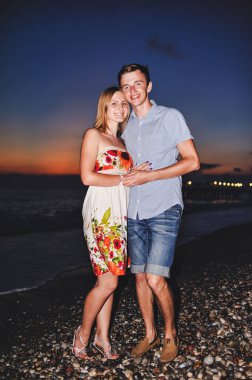 Seven sarılma ve suset, kum plajındaki gülümseyen genç Çift