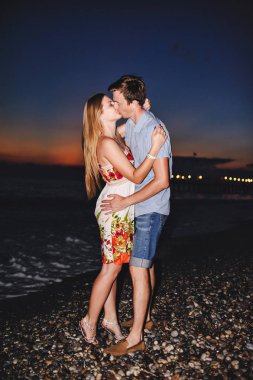 Seven sarılma ve suset, kum plajındaki gülümseyen genç Çift