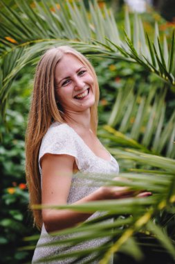 Genç kadın yeşil tropikal parkta poz