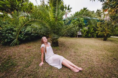 Genç kadın yeşil tropikal parkta poz