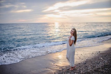 Kumsalda gün batımında poz sarışın genç kadın