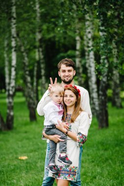 Genç aile ile oğul içinde nakış gömlek yürüyüş ve sahip olan eğlence içinde yeşil yaz Park 