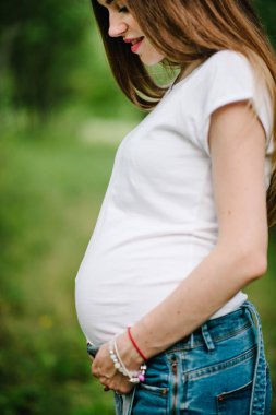 Yeşil yaz Parkında yürüyüş genç hamile mutlu kadın