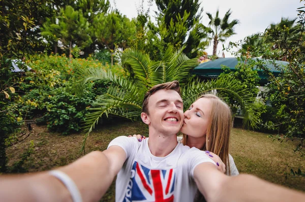 トロピカルパームパークで幸せな若いカップルのポーズ — ストック写真