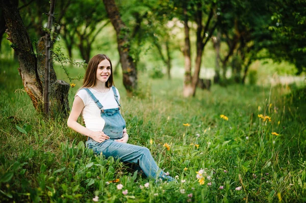 緑の夏の公園で歩く若い妊婦幸せな女性 — ストック写真
