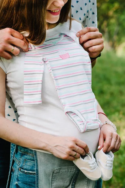 Donna Incinta Con Marito Che Tiene Scarpe Vestiti Bambini Sullo — Foto Stock