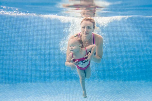 若い母はプールで水中で泳ぐために娘を教えます — ストック写真