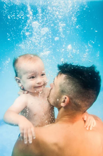 幼い父は息子にパドリングプールで水の下で泳ぐように教えます — ストック写真