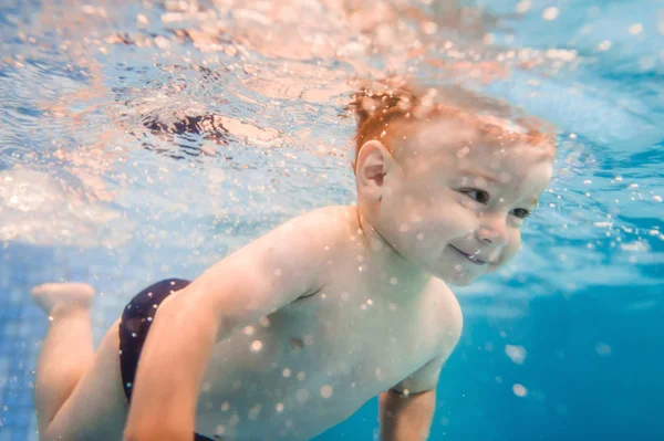 パドリングプールで水中を泳ぐ小さな男の子 — ストック写真