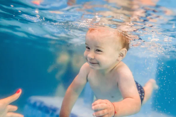 パドリングプールで水中を泳ぐ小さな男の子 — ストック写真