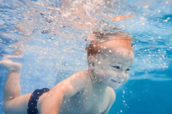 パドリングプールで水中を泳ぐ小さな男の子 — ストック写真