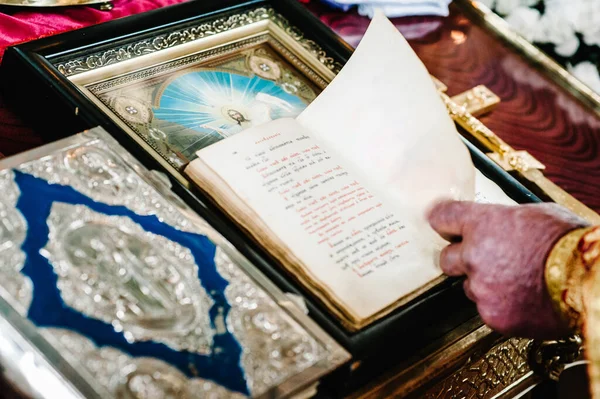 The priest holds and read the Bible in his hands. Priest during a wedding ceremony, celebrate a mass at the church. Close up.