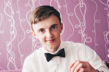 Mutlu damat pozu. Düğün sabahı. Kapat. Beyaz bir arka planda. Gülümse, portre