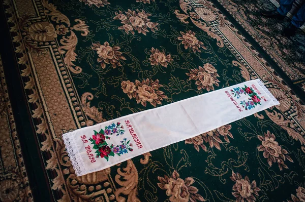 Wedding embroidered towel. Fortunately. To share. Fate. The towel is lying on the floor pad in the room. Wedding day. Close up. handmade.