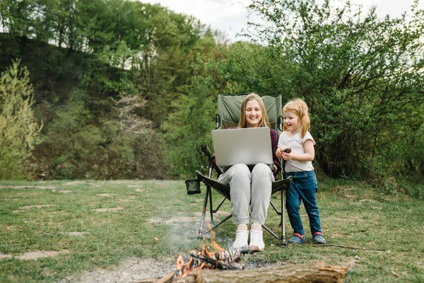 Homeschooling and freelance job. Mother working with kid outdoors. Quarantine and closed nursery school during coronavirus outbreak. Communicate with relatives, family online on laptop in nature.