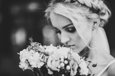 Düğün buketi ile çekici gelin portresi. Siyah beyaz fotoğraf.