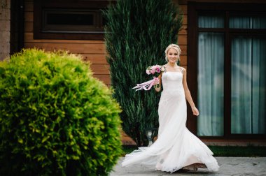 Şık bir elbise içinde, dans eden, dönen, düğün töreninde dönen genç ve güzel bir gelin..