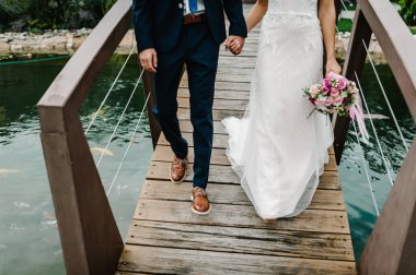 Göl kenarında düğün töreni. En alttaki çiftin görüntüsü. Yeni evliler. Gelin ve damat bir göl ya da nehir kıyısında yürüyorlar..