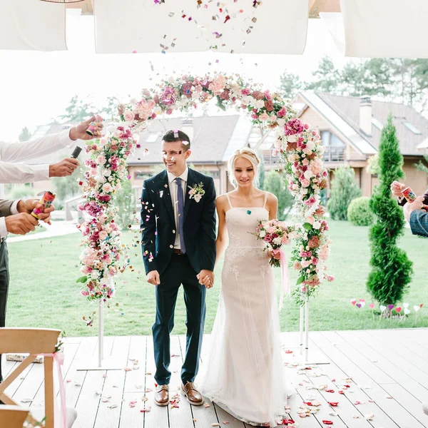 Braut Und Bräutigam Gehen Durch Den Bogen Der Mit Rosenblättern — Stockfoto