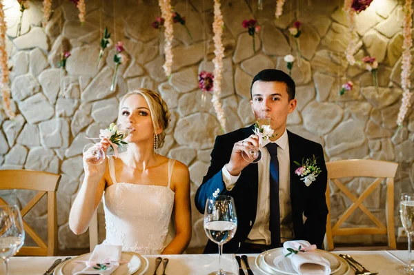 부부들은 실내에서 샴페인을 마신다 초목으로 결혼식 식탁에 신부와 — 스톡 사진