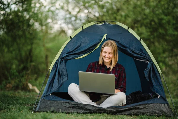 Communicate with relatives, family online on laptop in tent in nature. Female briefing the team at the conference or remote work consultation, woman worker speak talk on video call with colleagues.