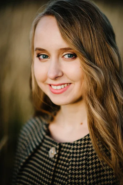 Sonbaharda arka planda güzel bir kızın portresi. Doğada. Üst yarı uzunlukta. Kapatın. Kameraya bakıyorum..